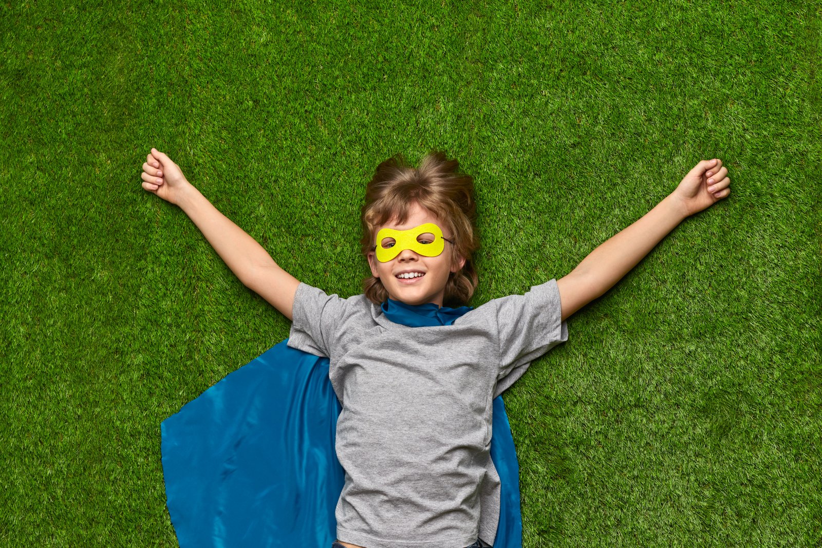 Child playing safely on a lush green lawn